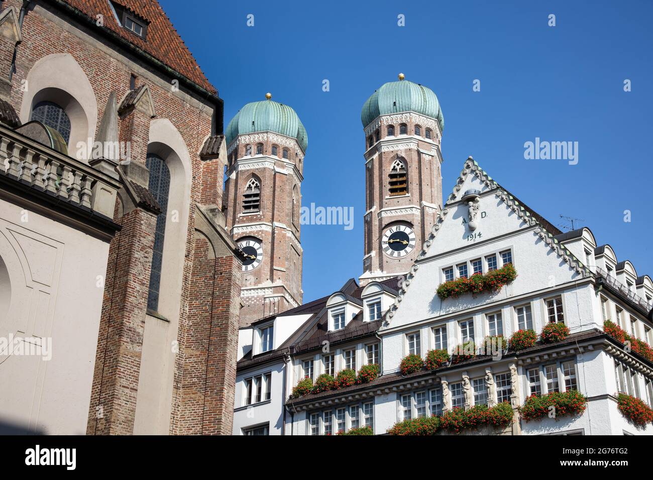 Die Türme der Frauenkirche hinter den Häusern der pdestrianischen Zone im Zentrum von München Stockfoto