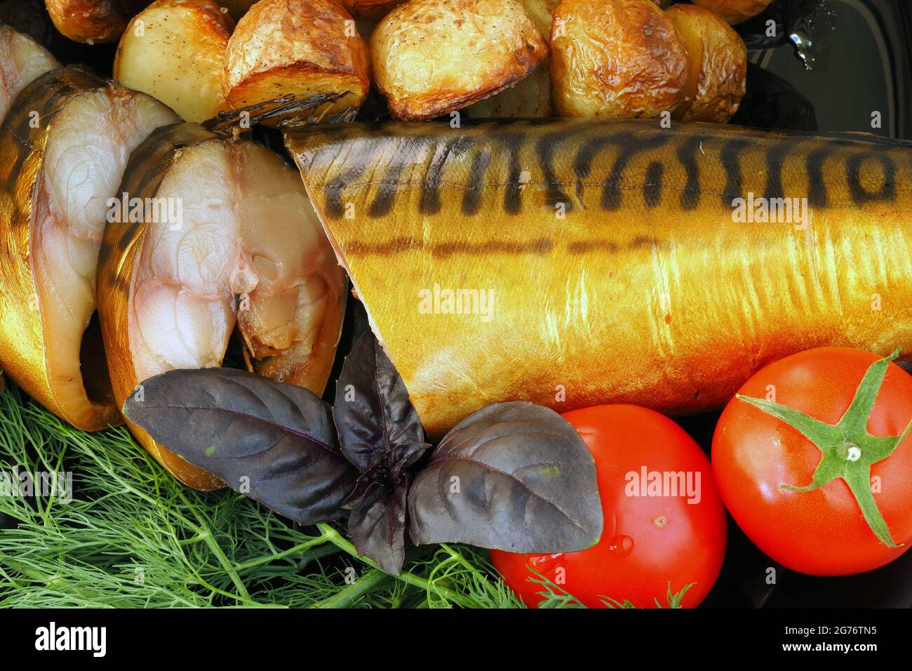 Geräucherte Makrele auf einem Teller mit Tomaten und Dillkartoffeln. Stockfoto