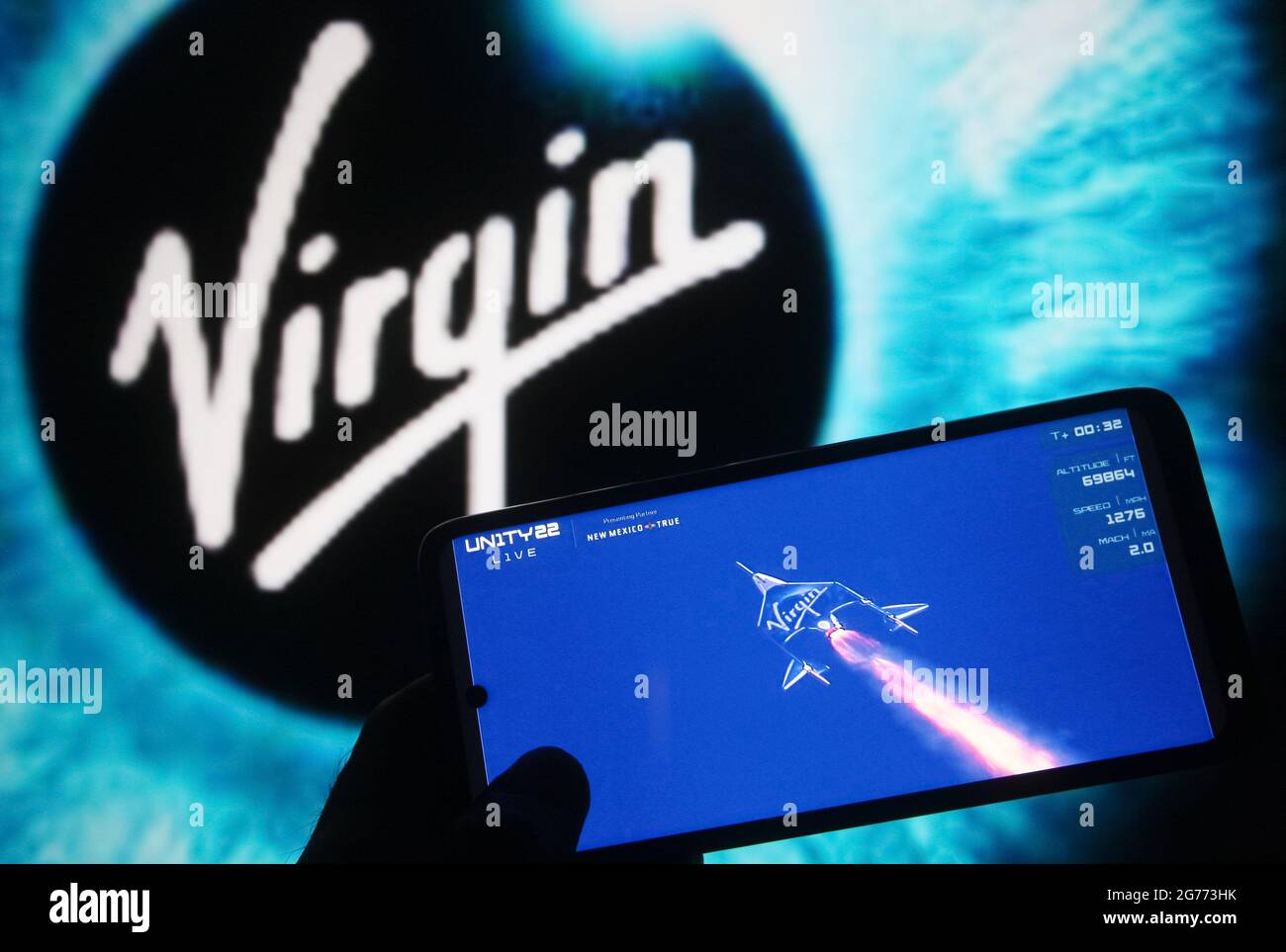 In dieser Abbildung ist das Weltraumflugzeug Virgin Galactic VSS Unity auf einem Fragment eines Weltraumfluges Virgin Galactic Unity 22 zu sehen Livestream Youtube-Videos, das auf einem Smartphone mit dem Virgin Galactic-Logo im Hintergrund angezeigt wird. Der britische Milliardär Richard Branson stieg am 11. Juli an Bord seiner Virgin Galactic VSS Unity-Weltraumrakete über 50 Meilen (was nach Angaben der Vereinigten Staaten die Grenze des Weltraums markiert) auf und landet sicher, Berichten zufolge durch Medien. Stockfoto