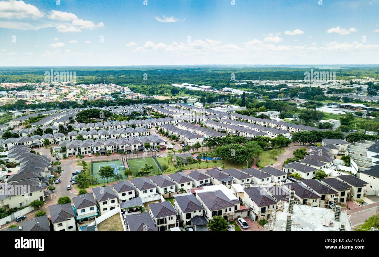 Eine Luftaufnahme der Häuser einer Wohnanlage in Guayaquil, Ecuador. Sonniger Tag. Dächer, Spielplätze, Bäume, Häuser bauen nebeneinander. Stockfoto