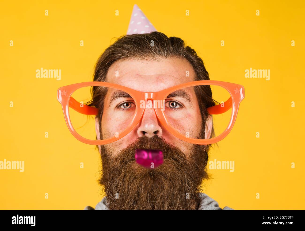 Partyzeit. Alles Gute zum Geburtstag. Bärtiger Mann in großer Brille. Feiertage und Feiern. Stockfoto