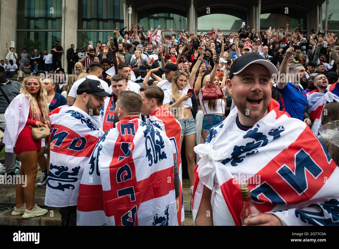 Manchester, Großbritannien. Juli 2021. Fußballfans, die mit der Flagge von St. Georges drapiert sind, kommen in die Stadt, um sich das Finale der Euro 2020 anzusehen, bei dem England Italien spielt. ÊAndy Barton/Alamy Live News Credit: Andy Barton/Alamy Live News Stockfoto