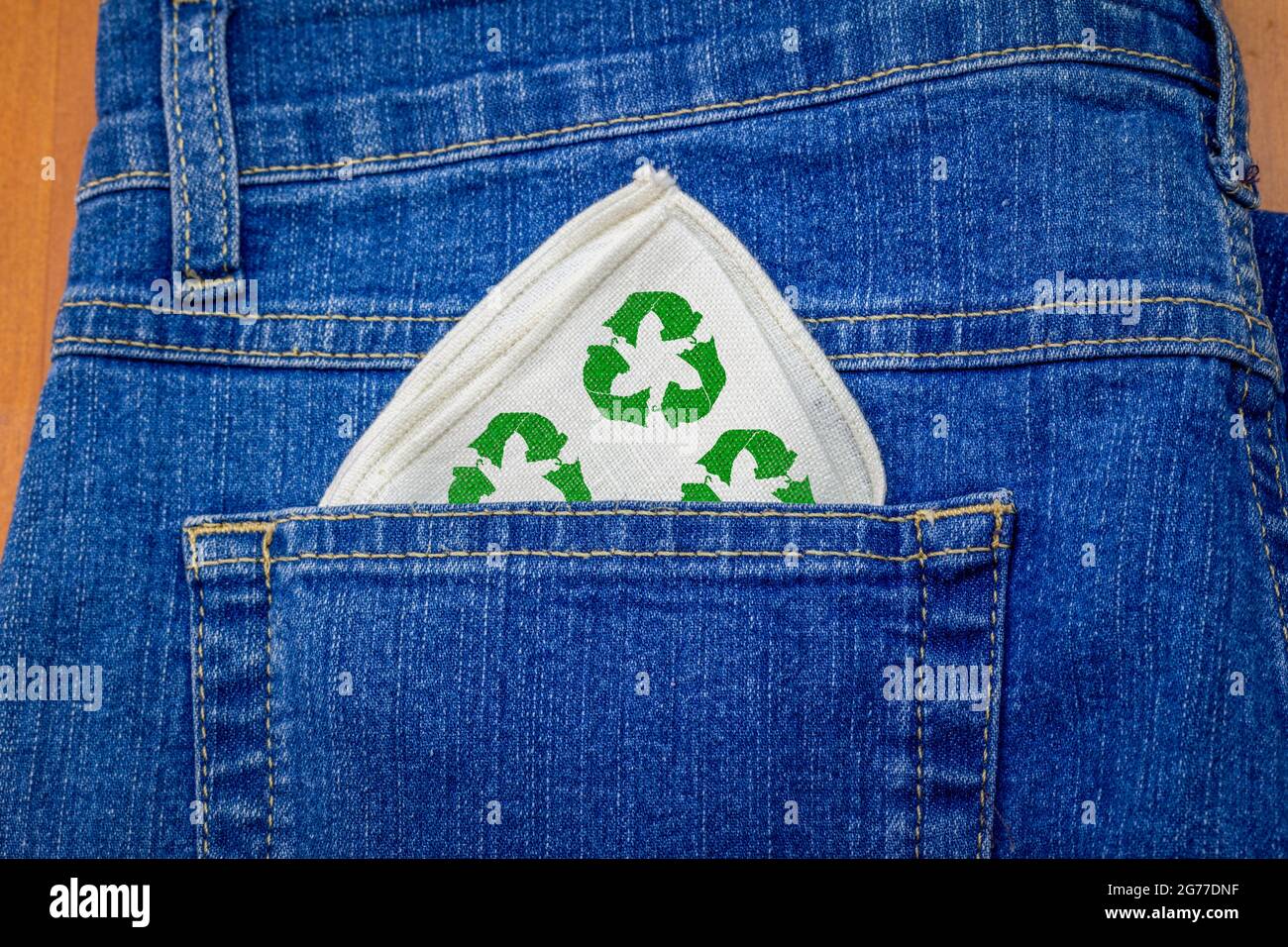 Wiederverwendbares Stoffhandy mit Recycling-Textilien-Symbol in der Jeans-Gesäßtasche, waschbares wiederverwendbares Taschentuch reduziert Verbrauch und Abfall Stockfoto