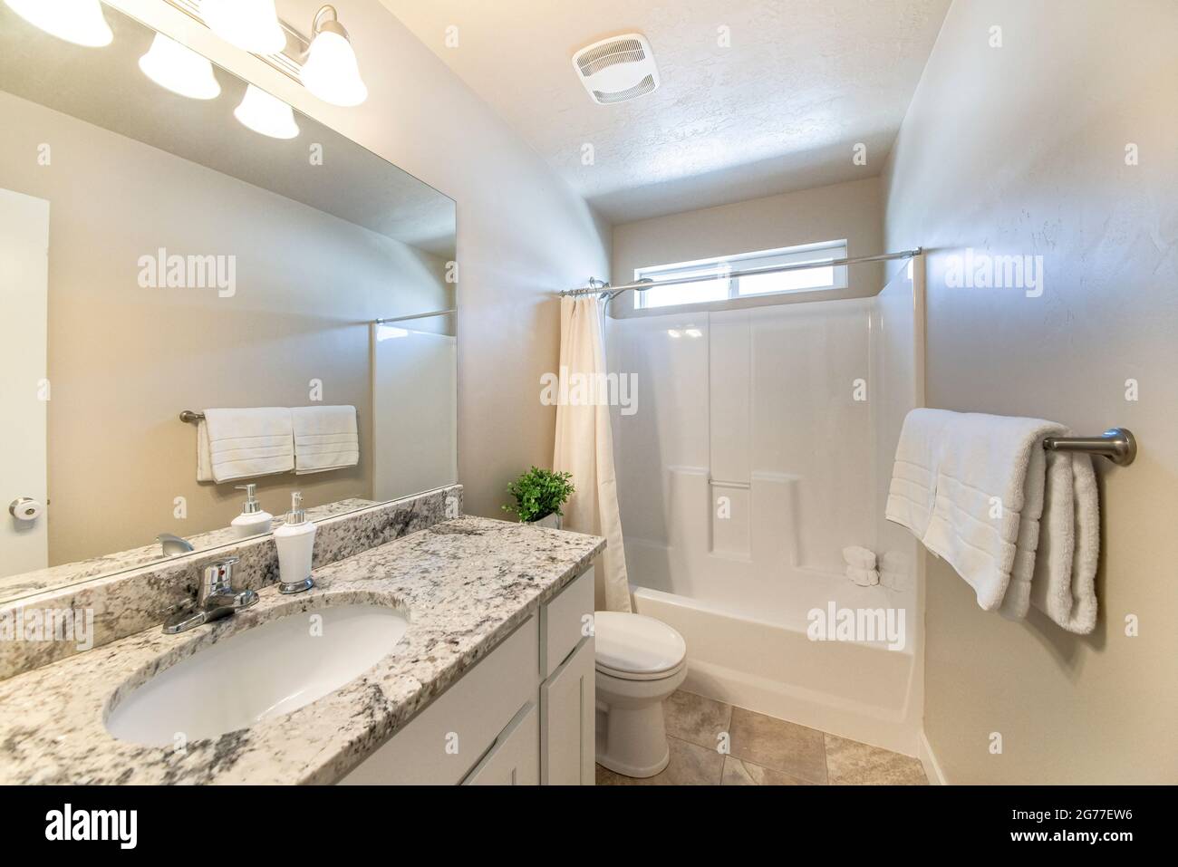 Kleines, schlichtes, weißes Badezimmer mit Schminktisch und Badewanne  Stockfotografie - Alamy