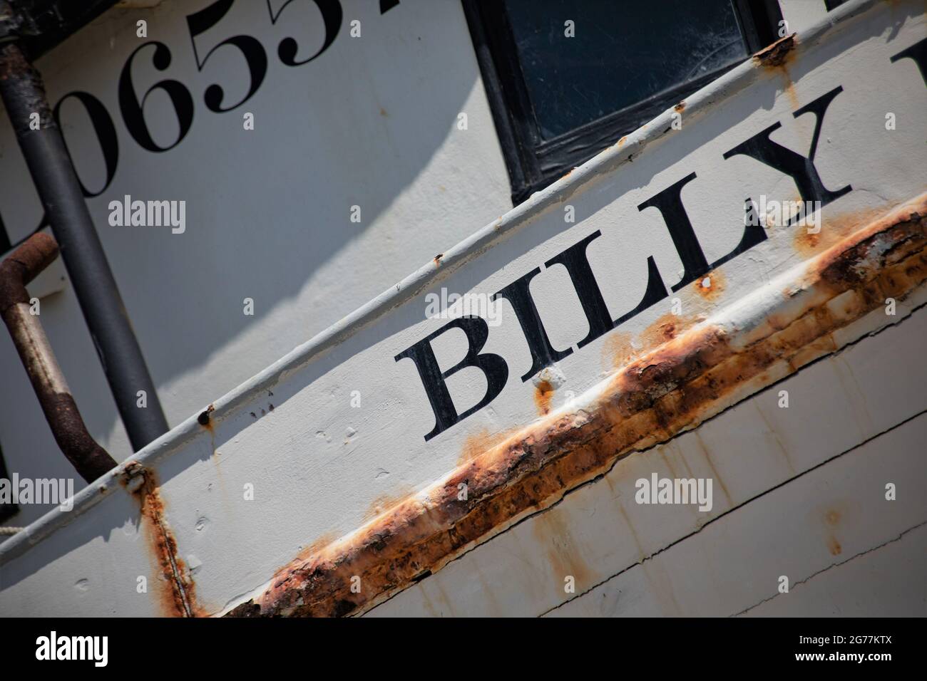 Älteres Fischerboot im Trockendock wartet auf Reparaturen und Lackierung von Exposé zur offenen Seeluft und salzigen Umweltbedingungen Stockfoto