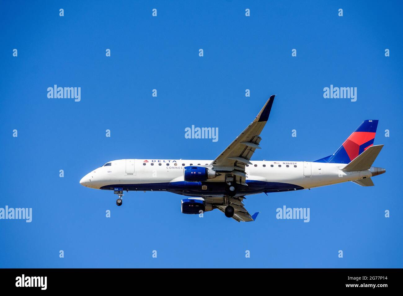 Delta Connection Embraer E175LR, ein Flugzeug von SkyWest Airlines, das sich auf die Landung am Flughafen mit eingelegtem Fahrwerk vorbereitet. Blauer Himmel - San Jose Stockfoto