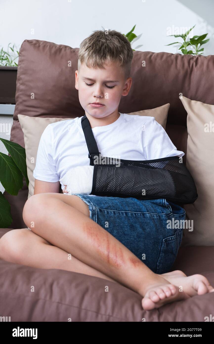 Trauriges Kind mit gebrochenem Arm in häuslichen Umgebung. Auf die Hand