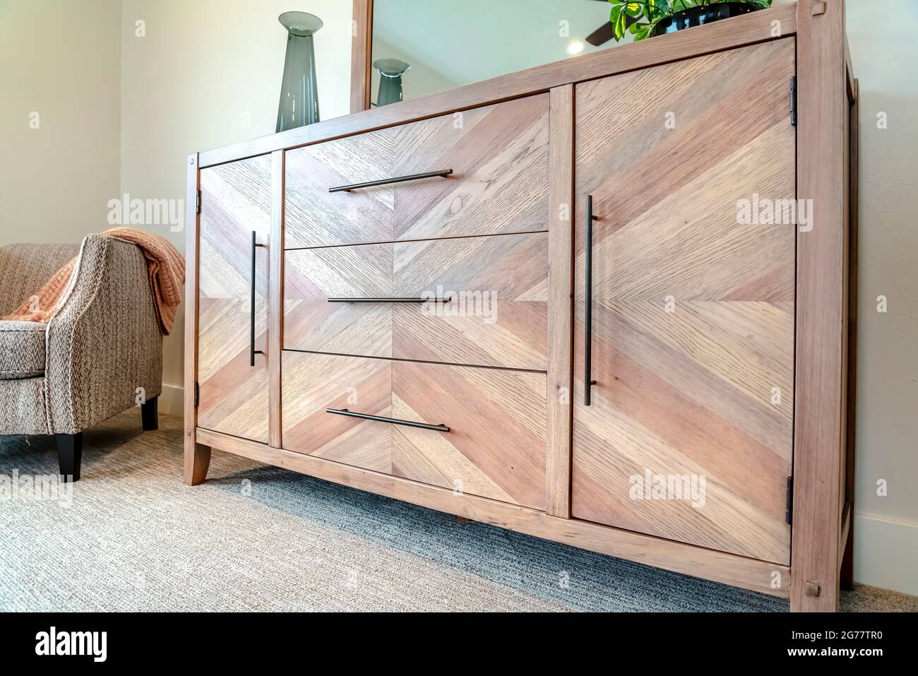 Waschtisch aus Holz und Polstersessel im Schlafzimmer des Hauses Stockfoto