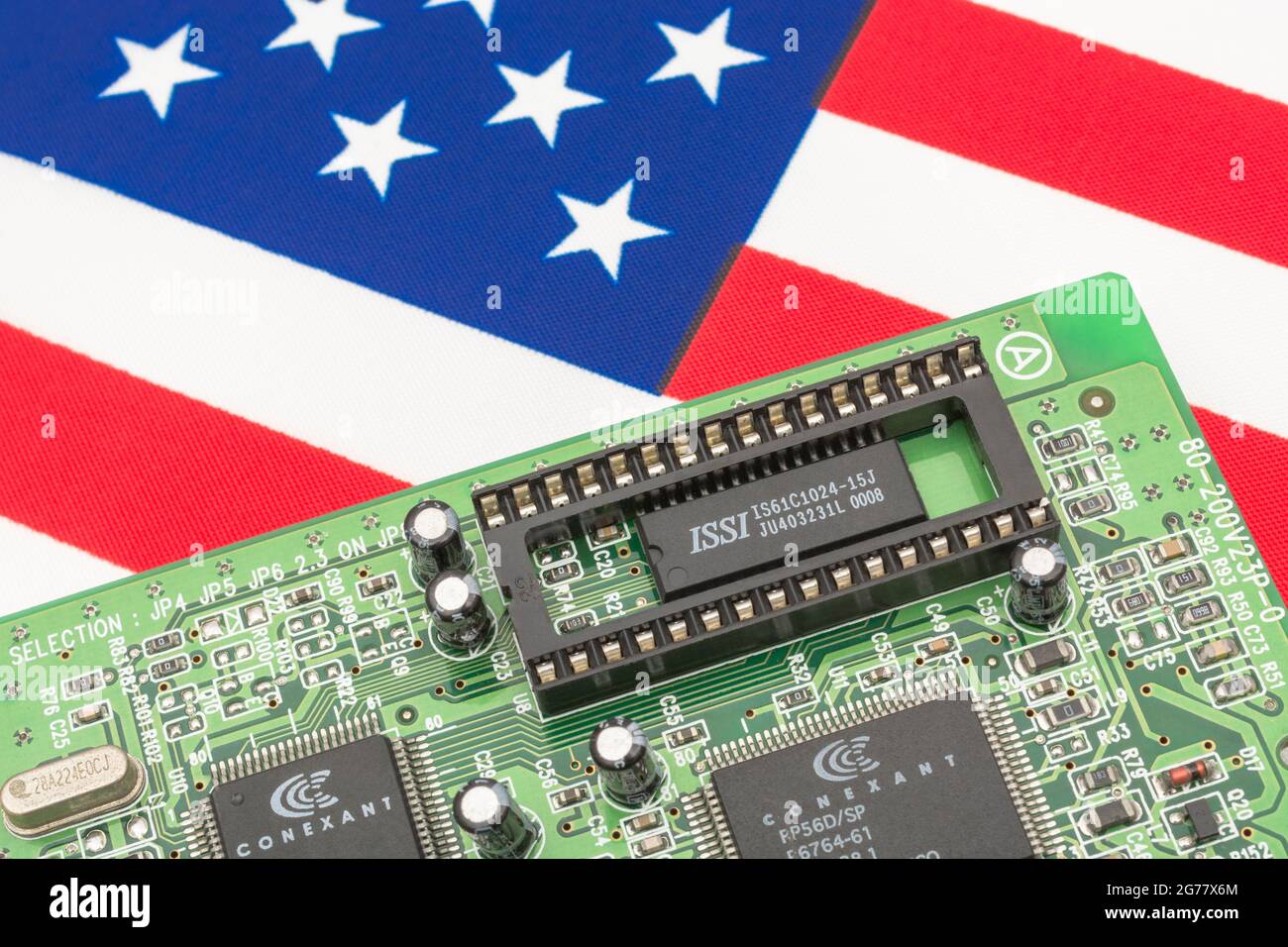 US Stars and Stripes-Flagge mit grüner Leiterplatte mit leerer EPROM-Buchse. Für 2021 Engpässe bei integrierten Computerchips, Halbleiterengpässe. Stockfoto