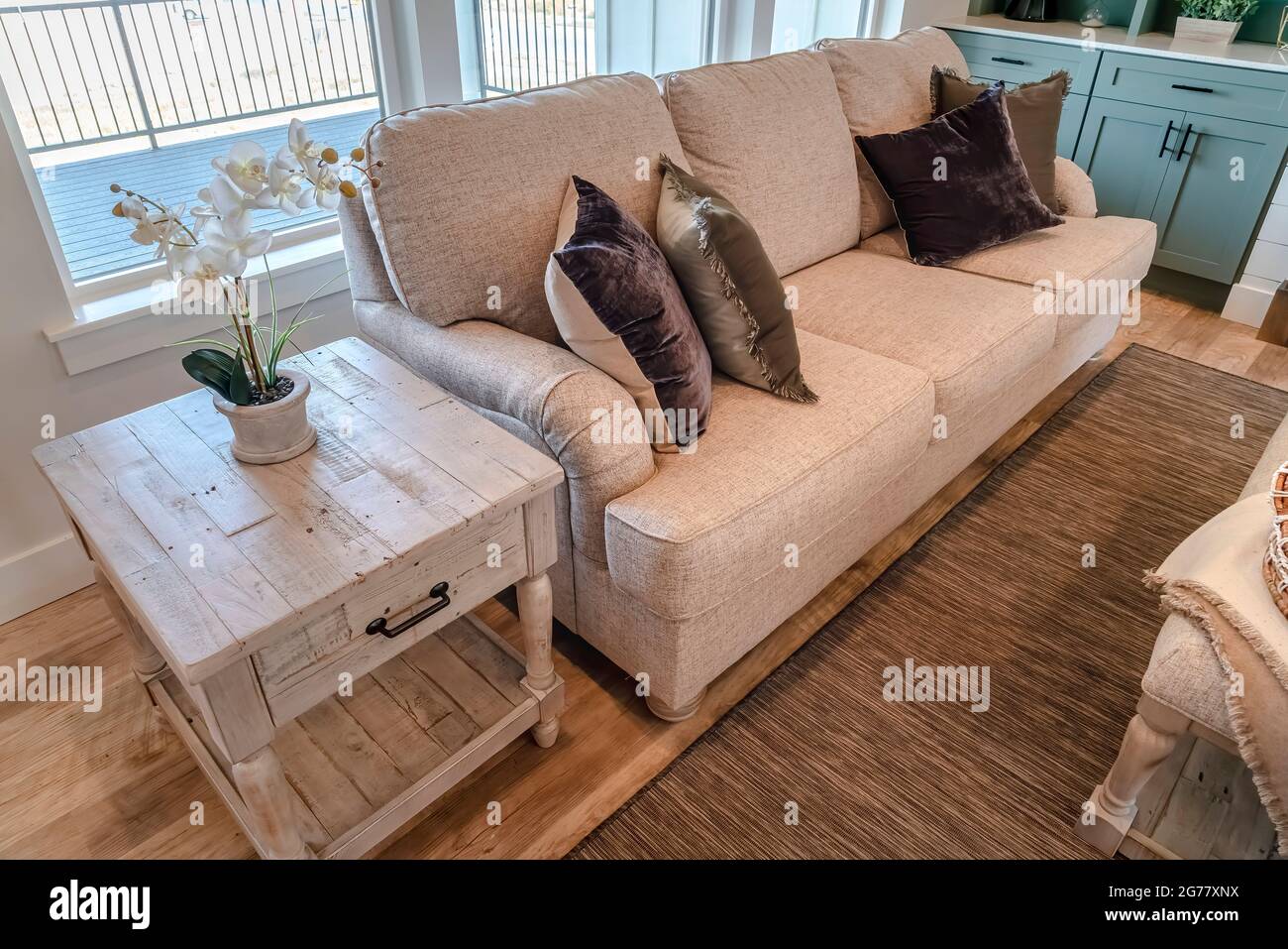 Beistelltisch und Sofa am Wohnzimmerfenster mit Blick auf die Veranda Stockfoto