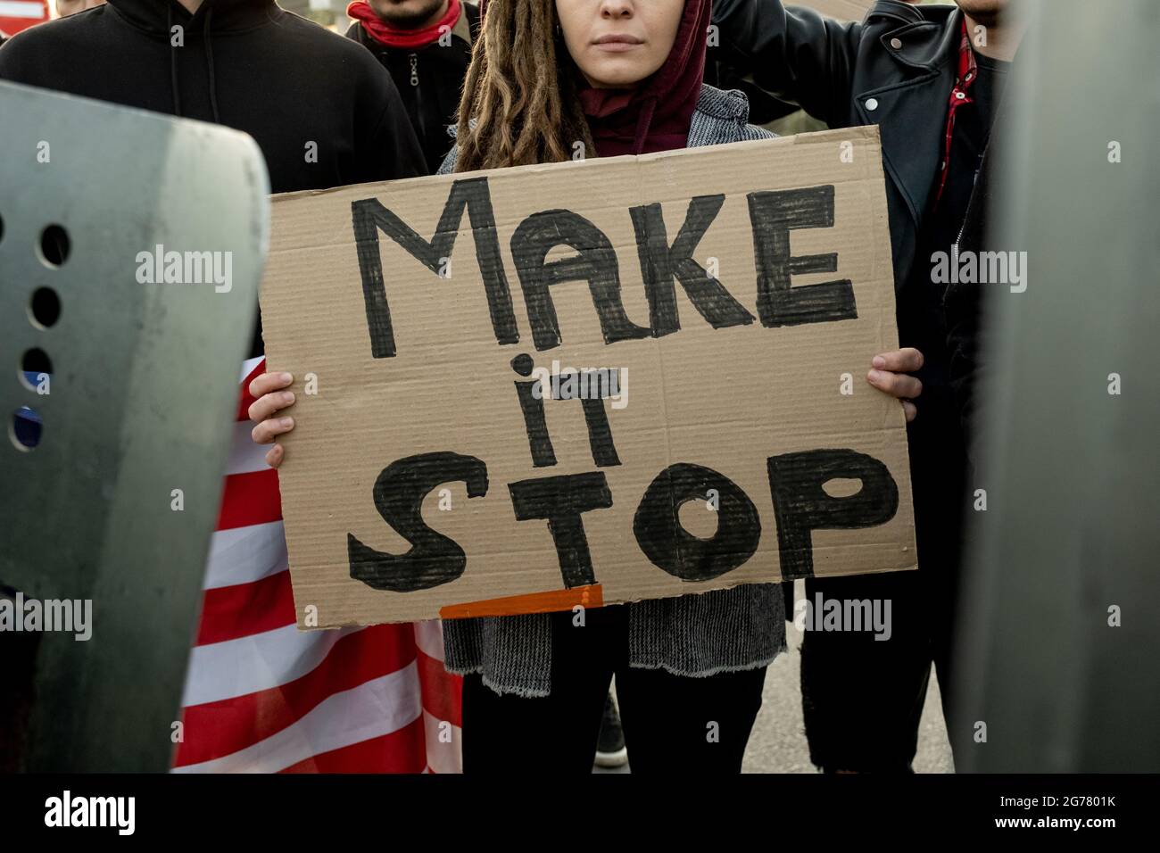 Nahaufnahme einer Frau mit einer Schreppe, die während der Kundgebung in der Menge steht und das Make-Stop-Pappbanner hält Stockfoto