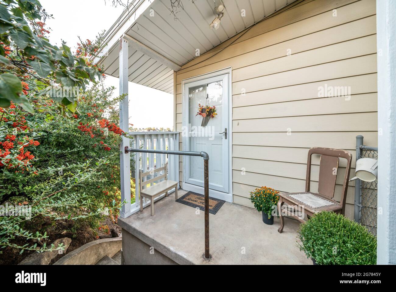 Vordertür außen eines Hauses im Landhausstil mit dekorativen Blumen und Pflanzen Stockfoto