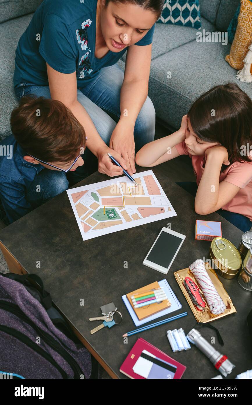Mutter erklärt ihren Kindern den Sammelpunkt für den Notfall Stockfoto