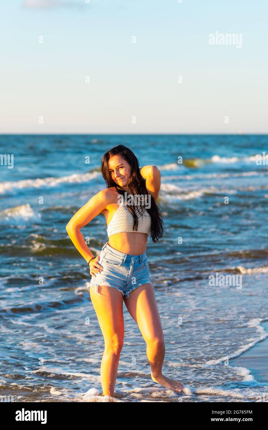 Junge Frau, die im Sommer im Meer spielt. Frau, die im Meerwasser genießt. Fröhliche junge Frau, die Spaß am Strand hat. Sie ist entspannt im Meerwasser und Stockfoto