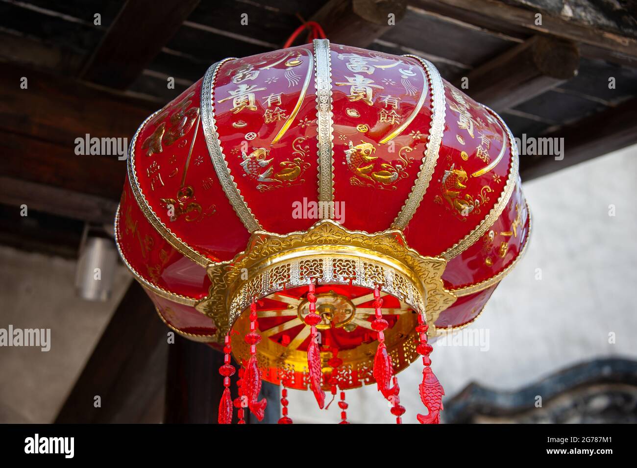 Jiangsu: Dekorative chinesische Laterne, die an einem alten Gebäude hängt. Diese roten Laternen sind in ganz China weit verbreitet und feiern oft Feste Stockfoto