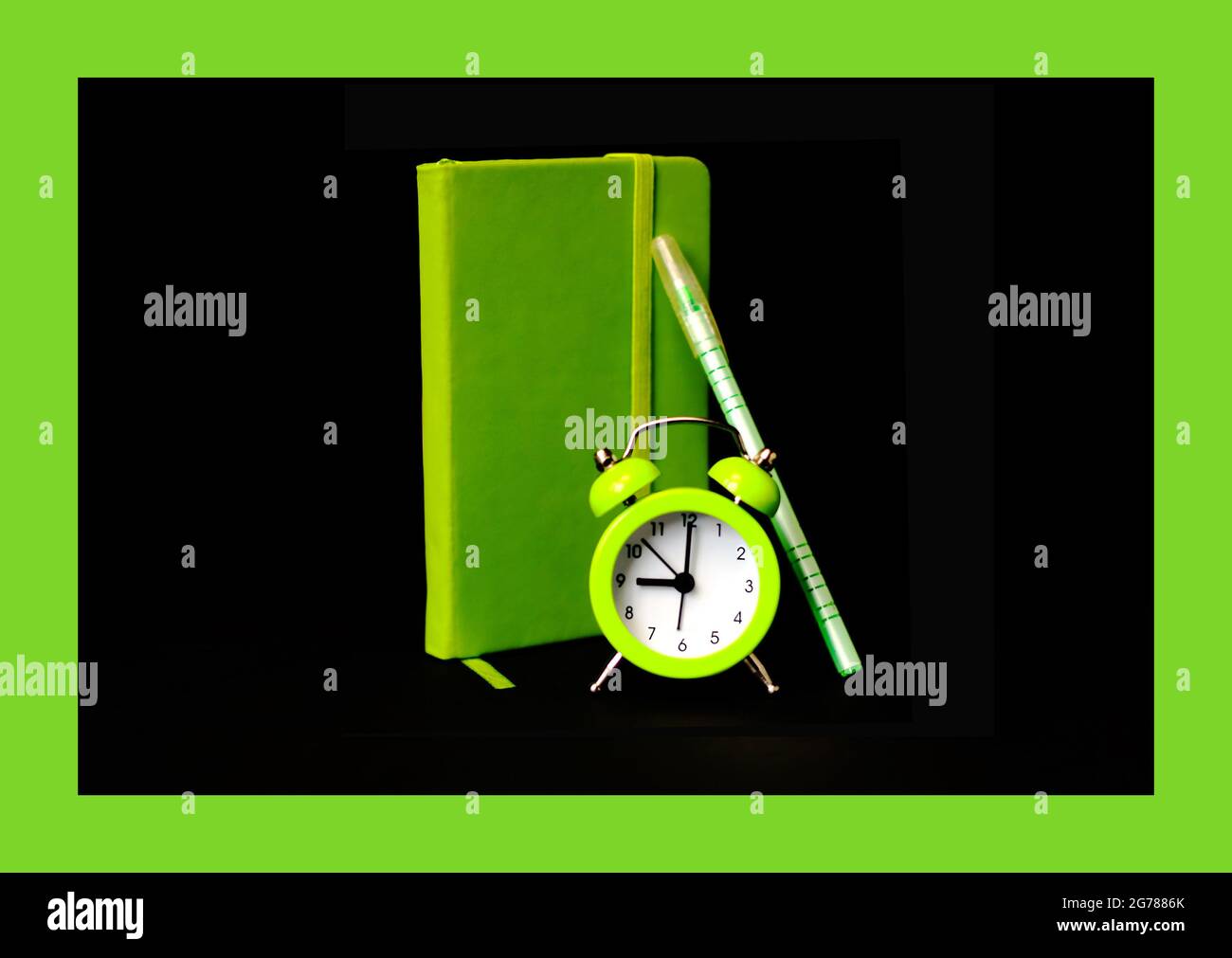 Hellgrüner Wecker auf schwarzem Hintergrund. Produktivitätskonzept hellgrünes Notebook und Stift. Zeitminimalistisches Konzept. Selektiver Fokus Stockfoto