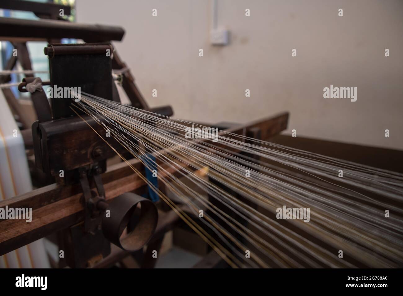 Nahaufnahme von Fäden, die beim Spinnen von Garn für die Textilindustrie entstehen. Weberei und verformende abstrakte Ansicht. Stockfoto