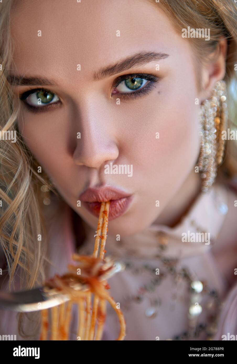 Schönes Mädchen, das Pasta (Spaghetti) isst. Nahaufnahme Porträt einer schönen jungen Frau Stockfoto