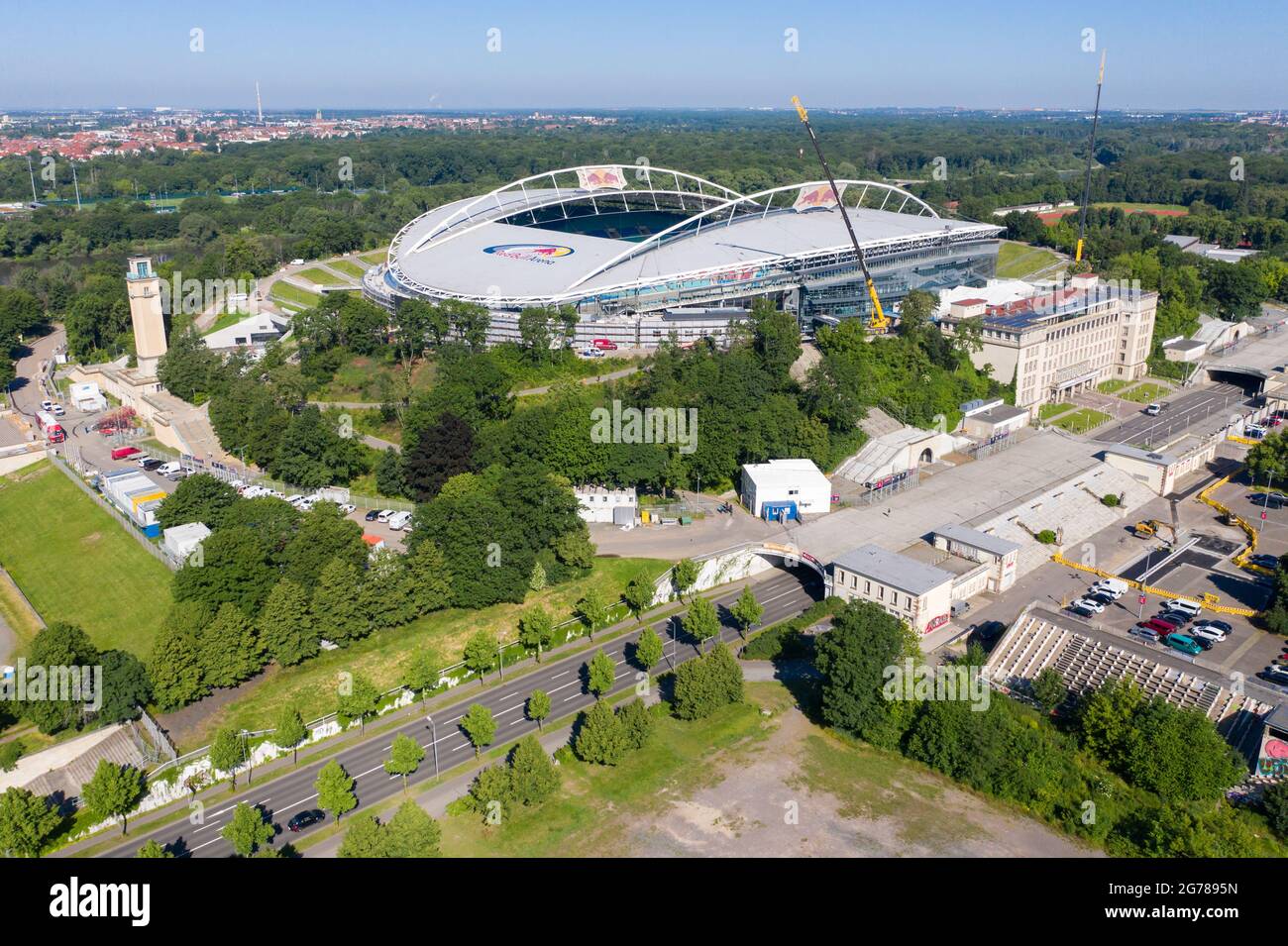 14. Juni 2021, Sachsen, Leipzig: Zwei Krane stehen in der Red Bull Arena. Das Heimgelände von RB Leipzig wird umgebaut. Die Zuschauerkapazität erhöht sich von 42,558 auf 47,069 im Stehen und Sitzen. Die Außenseite des Stadions ist von einer schalldichten Fassade umgeben. Der Damm des ehemaligen Zentralstadions, das die Arena umfasst, wurde hinter dem historischen Glockenturm aufgeschnitten, um Platz für einen neuen Eingang zu schaffen. RB Leipzig investiert bis 2022 gut 60 Millionen Euro in den Umbau. (Luftaufnahme mit Drohne) Foto: Jan Woitas/dpa-Zentralbild/ZB - WICHTIGER HINWEIS: Gemäß den Vorschriften der t Stockfoto