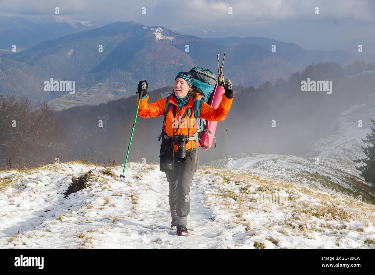 Glückliche Wandererin auf dem Bergweg. Aktivurlaub in den Bergen Stockfoto