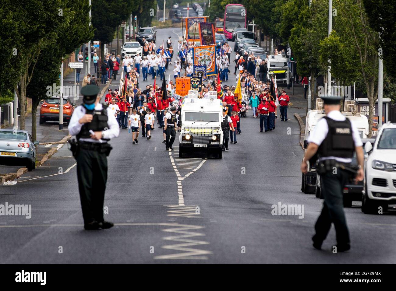 Bandsmen und Mitglieder des Ordens Nr. 3 District die loyale Orange Lodge-Parade führt im Rahmen der jährlichen Feierlichkeiten zum 12. Juli durch die nationalistische Gegend um Ardoyne-Geschäfte in Belfast, die den Sieg von König Wilhelm III. Über James II. In der Schlacht von Boyne im Jahr 1690 markieren. Bilddatum: Montag, 12. Juli 2021. Stockfoto