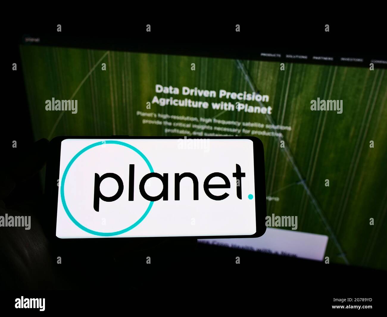Person mit Mobiltelefon und Logo des amerikanischen Earth Imaging-Unternehmens Planet Labs Inc. Auf dem Bildschirm vor der Webseite. Konzentrieren Sie sich auf die Telefonanzeige. Stockfoto
