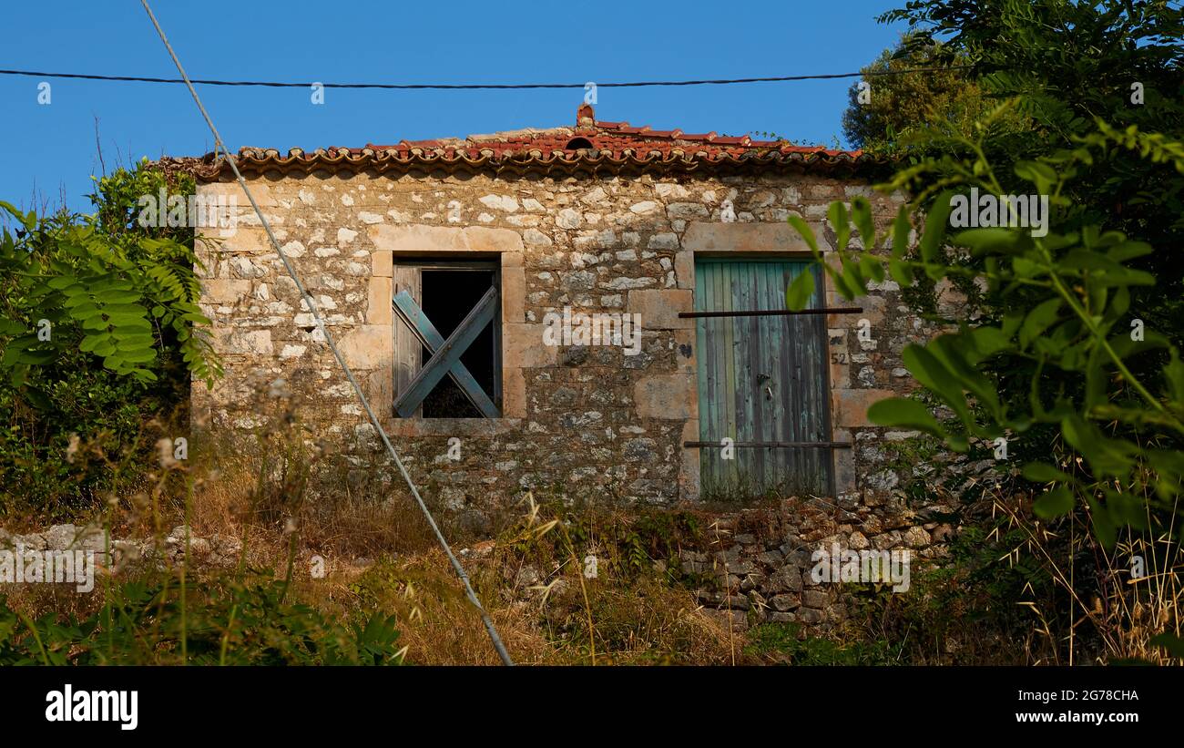 Ionische Inseln, Ithaca, Insel Odysseus, nordwestlich, Bergdorf Exogi, Verlassene Steinhaus, Holzkreuz im Fensterloch, grüne Tür Stockfoto