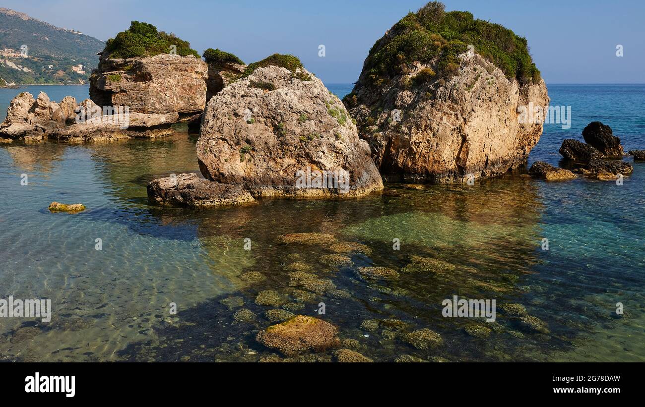 Ionische Inseln, Zakynthos, südlich der Stadt Zakynthos, Banana Beach, kleine Felsen vor dem Meer, bewachsen, meergrün und kristallklar, kleine Felsen sichtbar unter Wasser Stockfoto
