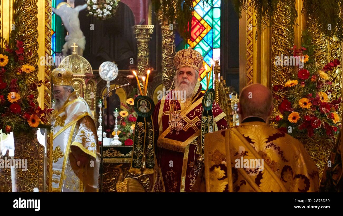 Ionische Inseln, Zakynthos, Stadt Zakynthos, Kirche des heiligen Dionysius, Fest des heiligen Dionysius am 17. Dezember stehen drei orthodoxe Geistliche vor dem Chor, prächtige Gewänder, Kerzen brennen, Buntglasfenster im Hintergrund Stockfoto