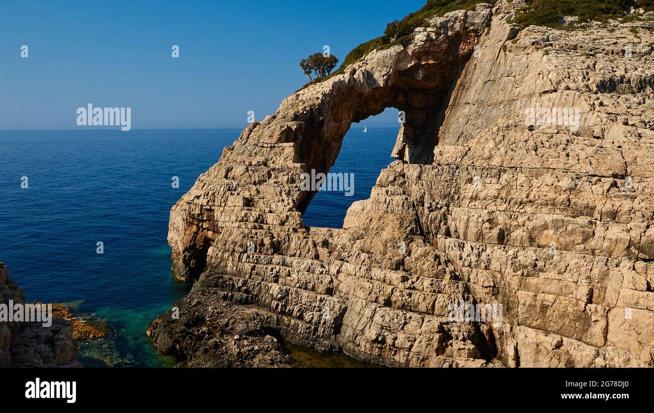 Ionische Inseln, Zakynthos, Westküste, Adria, Korakonissi, Felseninsel, Felstor, Loch in Insel, durch das Loch kann man ein weißes Segelboot auf dem offenen Meer sehen Stockfoto