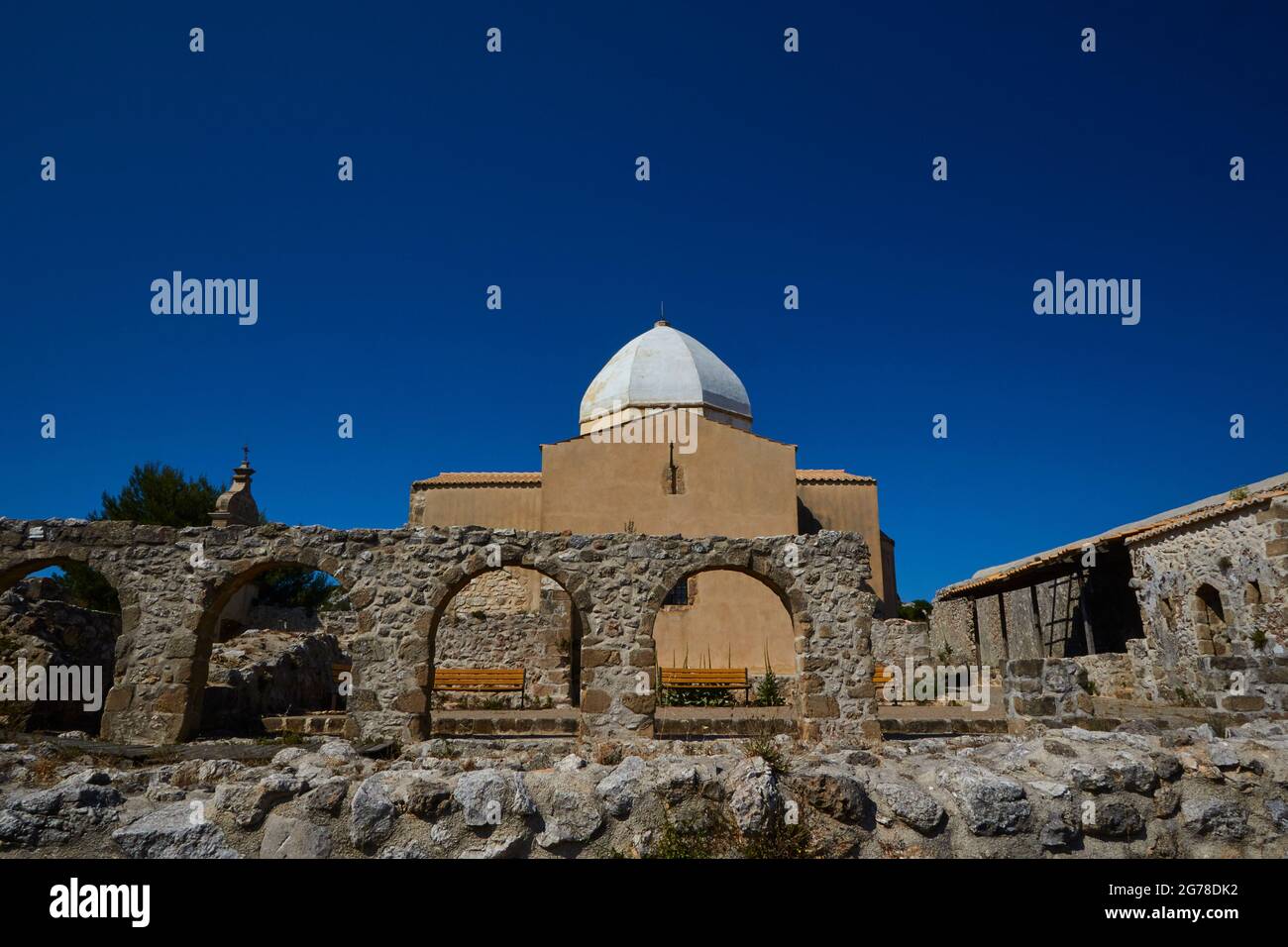 Ionische Inseln, Zakynthos, Berg bei Zakynthos Stadt, Monte Yves, Kloster auf dem Gipfel, Panagia Skopiotissa, 15. Jahrhundert n. Chr., steht auf Ruinen eines antiken Artemis-Tempels, dunkelblauer Himmel, niedrige Mauer im Vordergrund, Steinmauer mit Rundbögen in der Mitte, Kirche mit achteckiger Kuppel als Hauptmotiv, Stockfoto