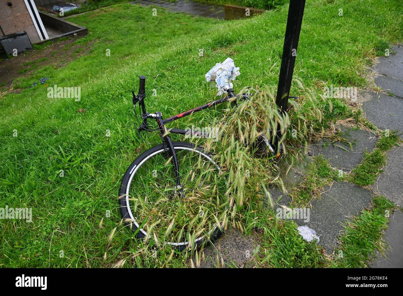 Das verlassene Fahrrad wurde einem Posten in Brighton Sussex UK mit einem Vorhängeschloss verschlossen Stockfoto