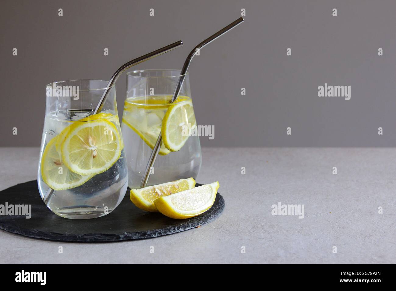 Kalte Getränke in kleinen Flaschen. Kirschen und Zitronenlimonade oder Cocktail. Stockfoto
