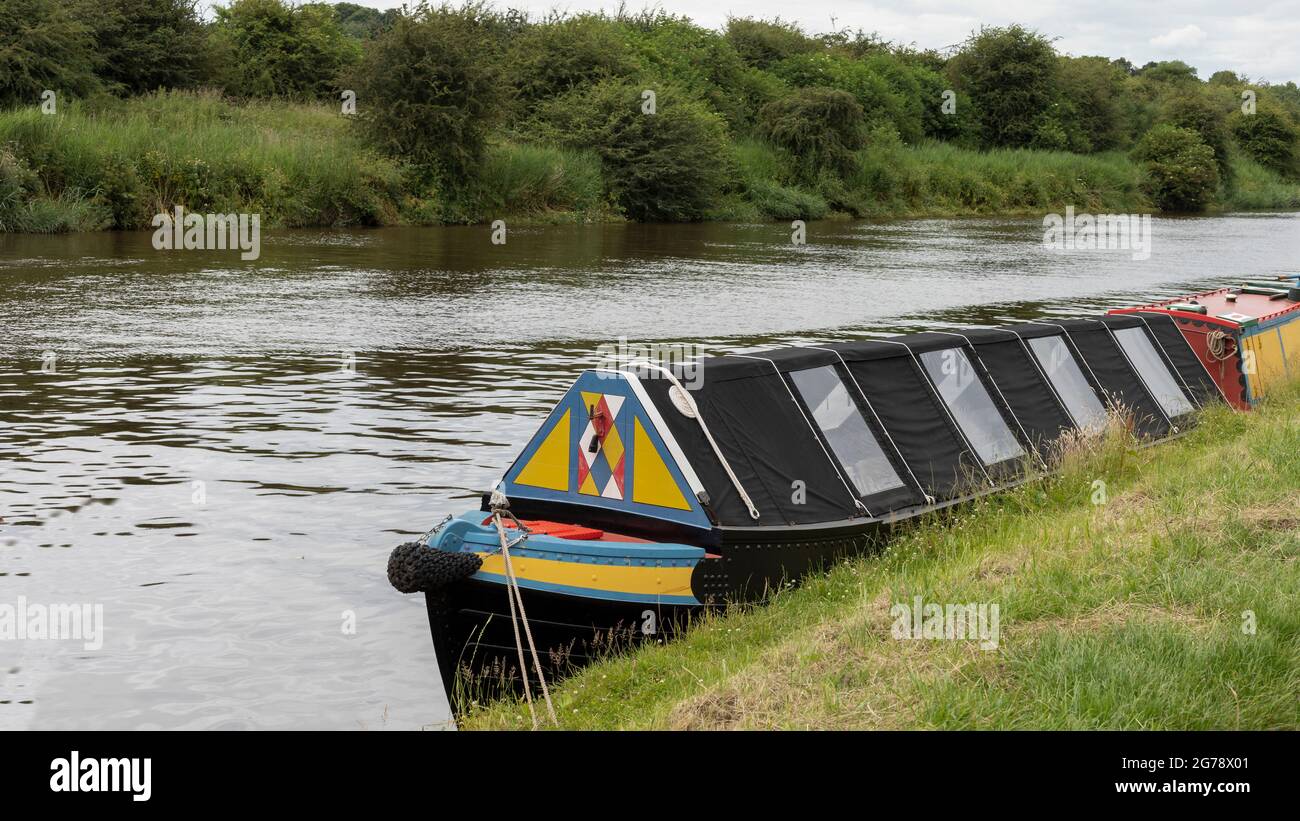 Das Kanalboot auf dem Fluss hat leuchtende Farben gemalt Stockfoto