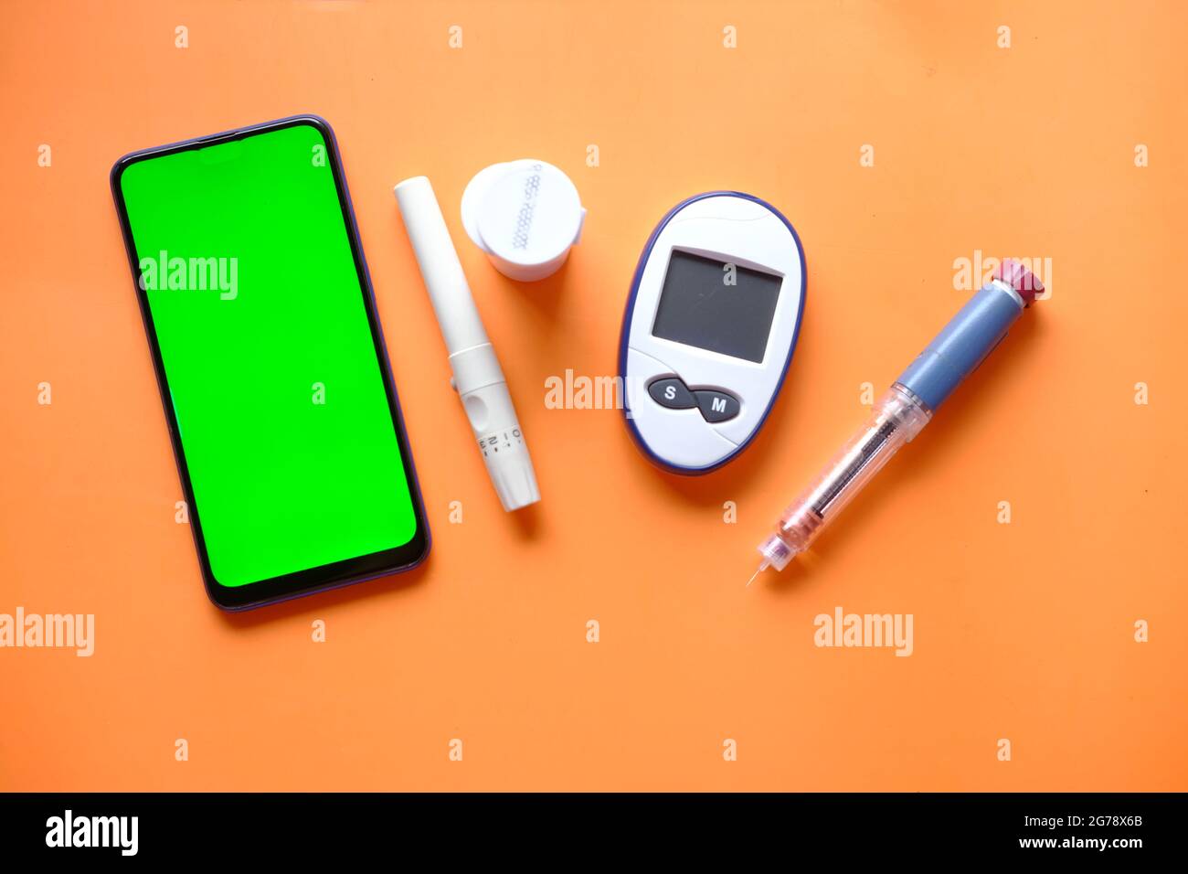 Insulinstift, diabetische Messwerkzeuge ein Smartphone mit leerem Platz auf dem Tisch Stockfoto