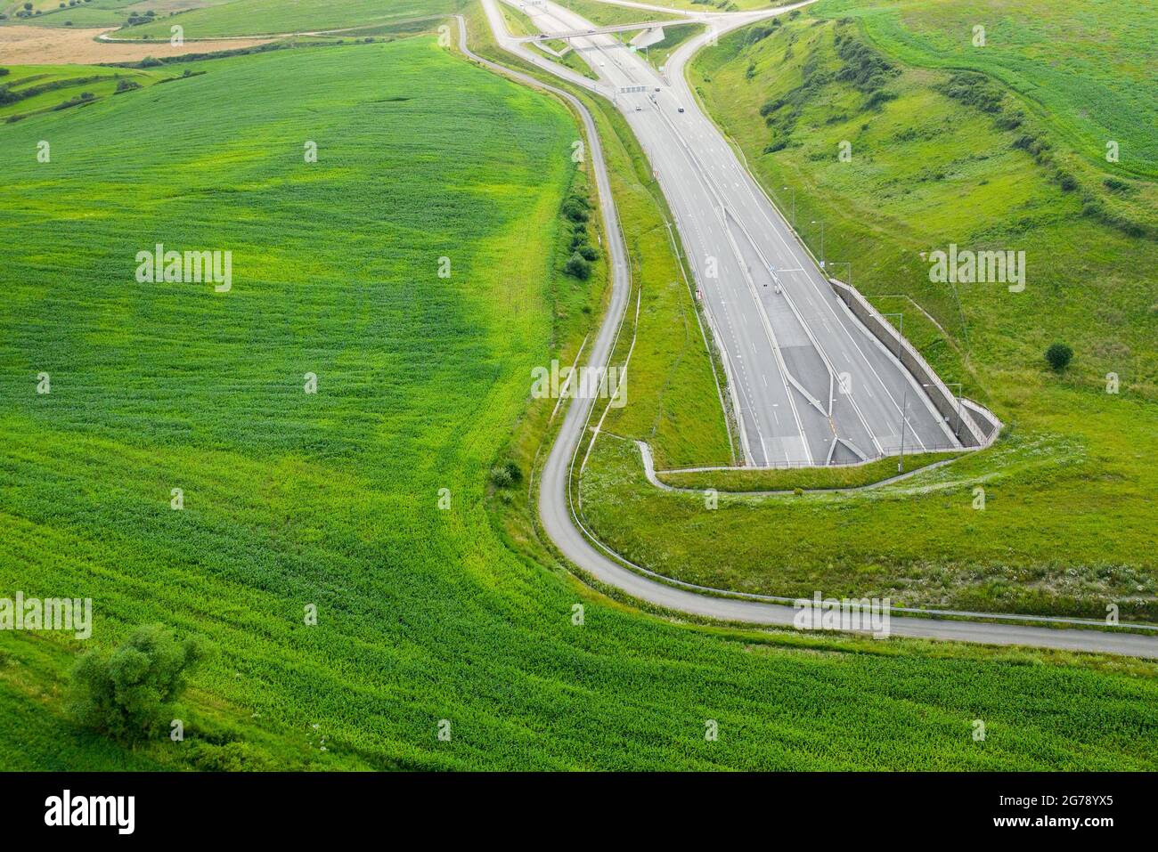 Draufsicht auf den Tunneleingang der Autobahn mit grünem Gras bedeckt Stockfoto