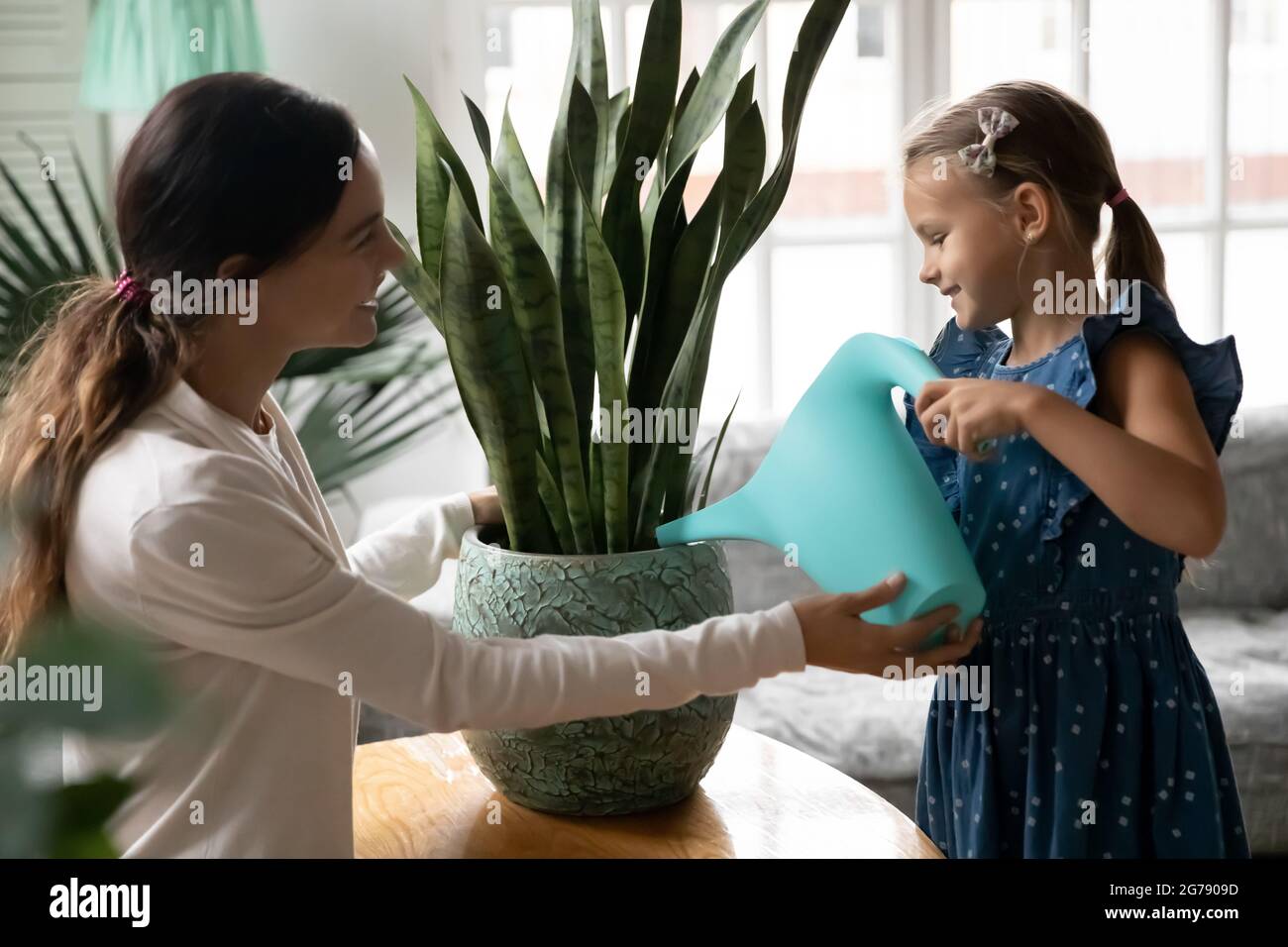 Lächelnde Mutter und kleine Tochter Wasserhausanlage Stockfoto