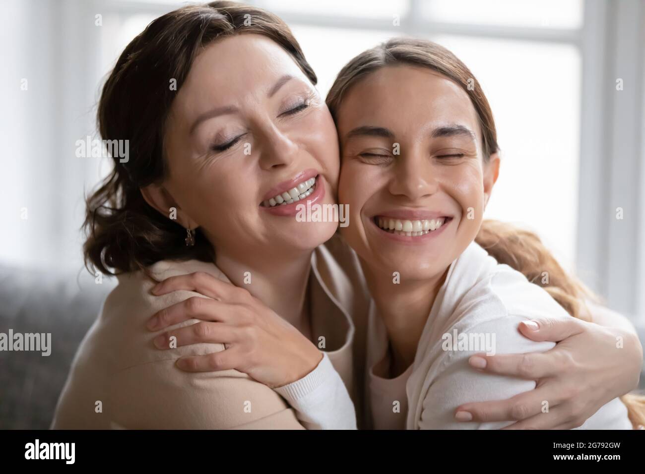 Glückliche ältere Mutter und Erwachsene Tochter umarmen zu Hause Stockfoto