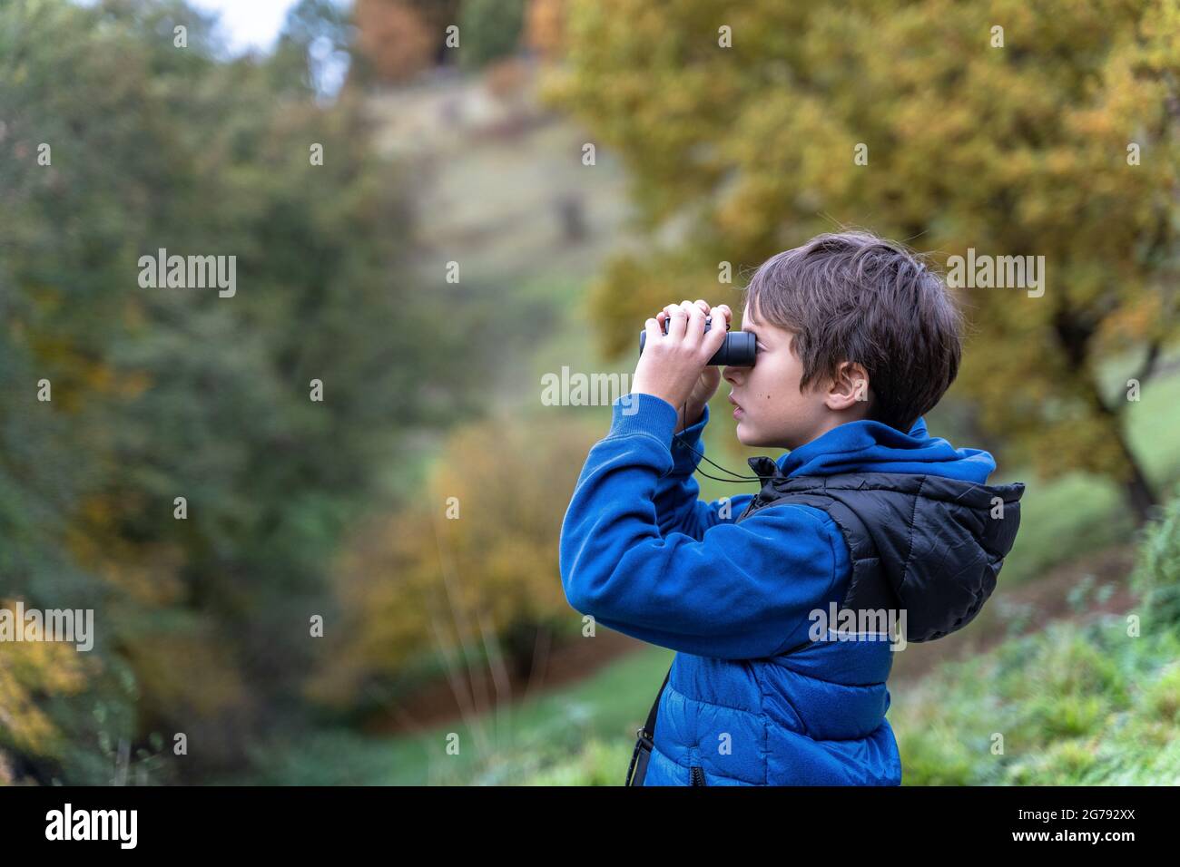 Europa, Deutschland, Baden-Württemberg, Stuttgart, Junge blickt durch ein Fernglas auf die Landschaft Stockfoto
