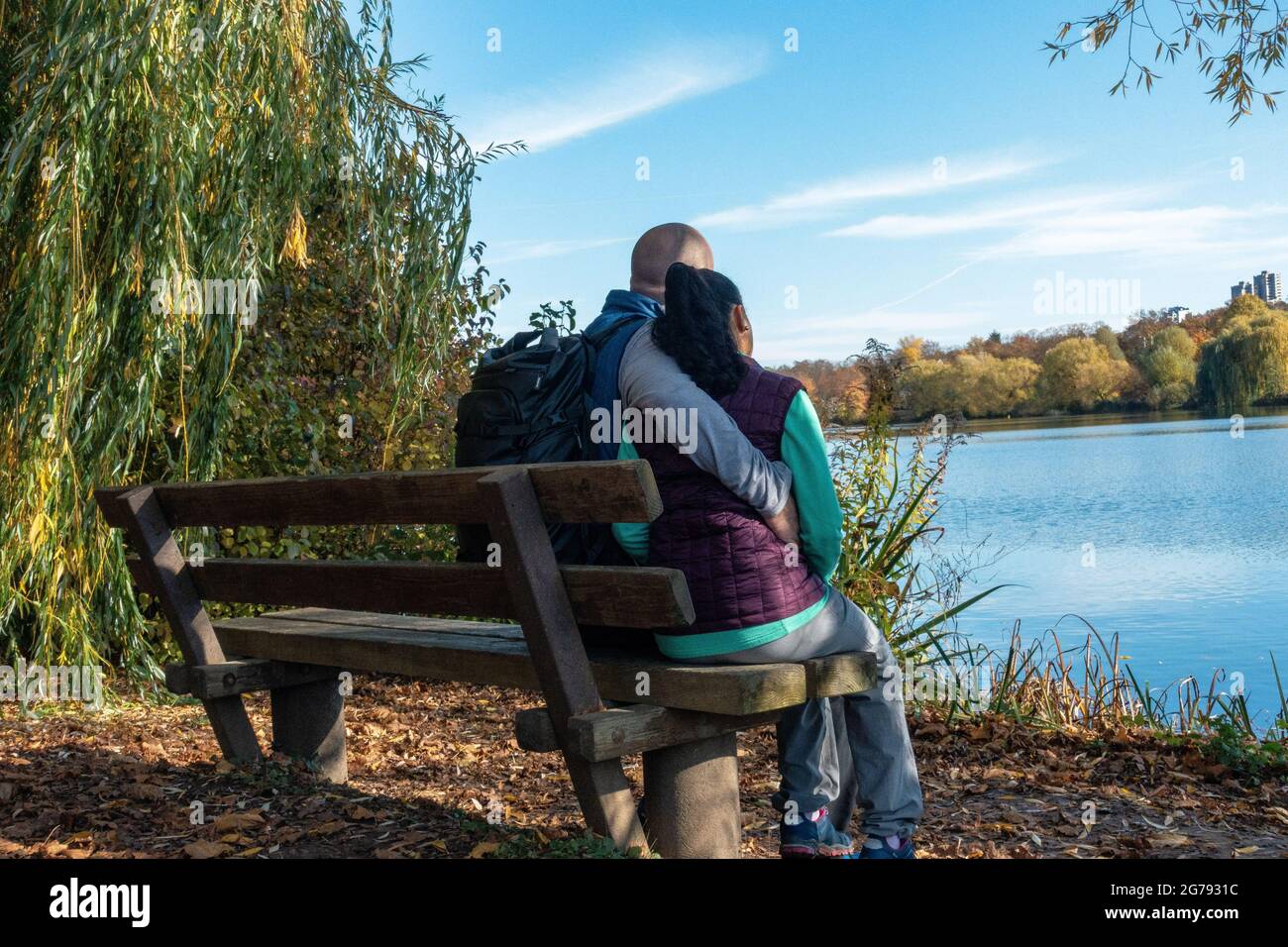 Europa, Deutschland, Baden-Württemberg, Stuttgart, Paar sitzt auf einer Bank und blickt auf den herbstlichen Max-Eyth-See Stockfoto