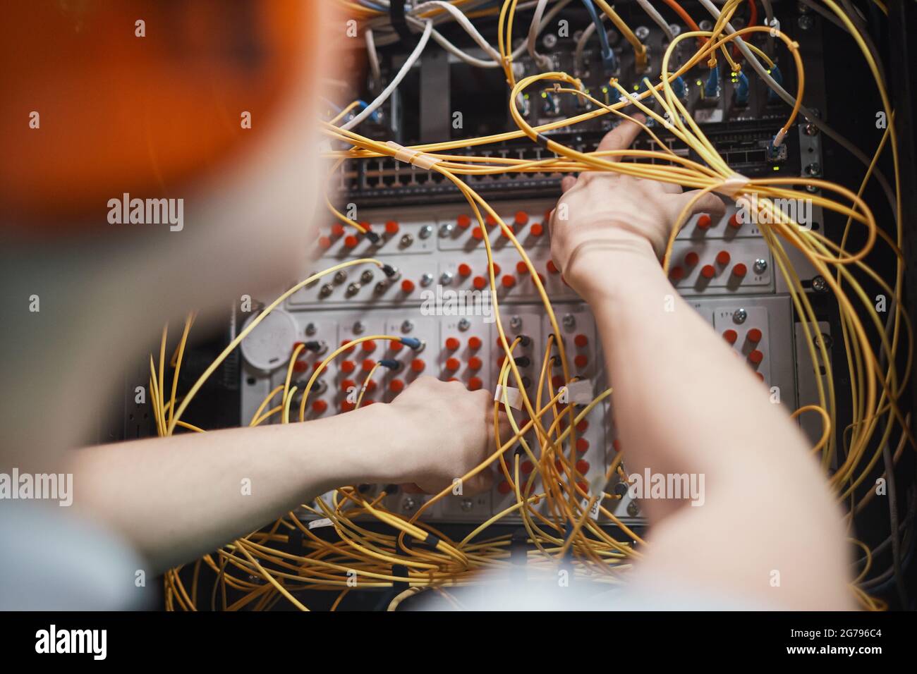 Nahaufnahme des Netzwerktechnikers, der während der Wartungsarbeiten im Rechenzentrum Kabel im Serverraum anschließt, Platz kopieren Stockfoto