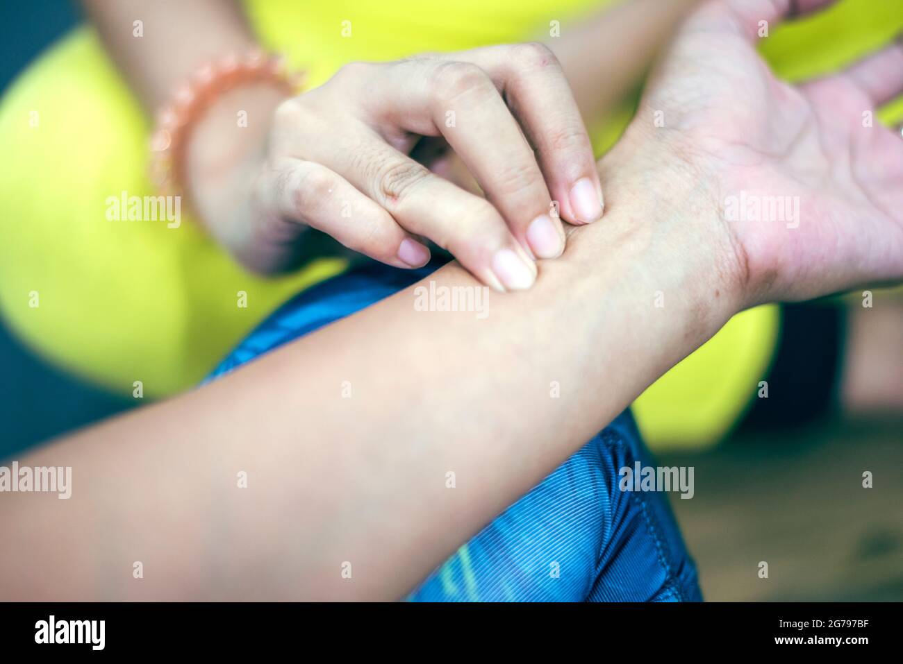 Trainer Hände Gefühl Puls auf weibliche Handgelenk. Health Care Concept.Cross-Verarbeitung und Split-Ton neue Farbtrend wie Prozess. Stockfoto