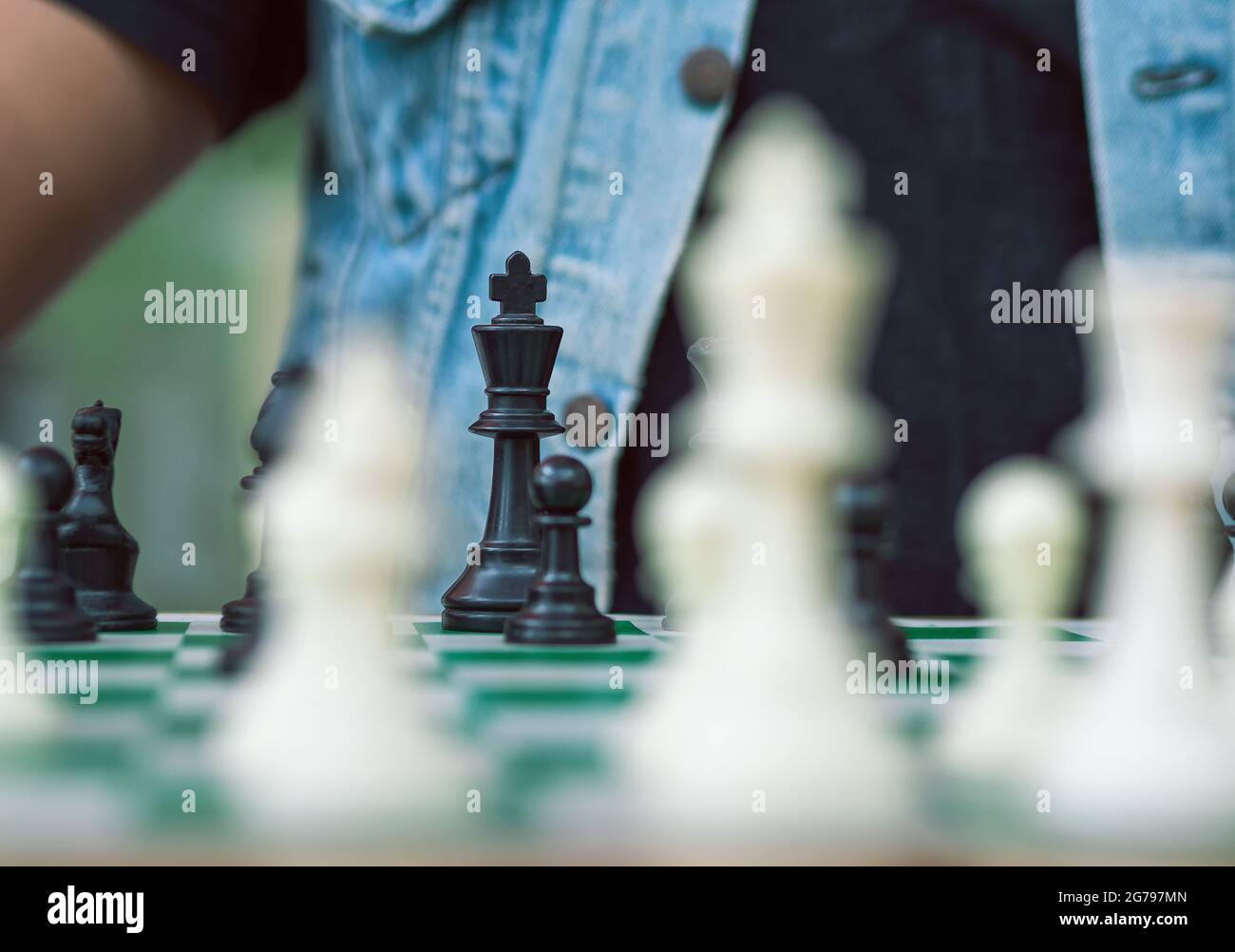 Schachspiel auf einem grünen Brett, dem schwarzen König Stockfoto
