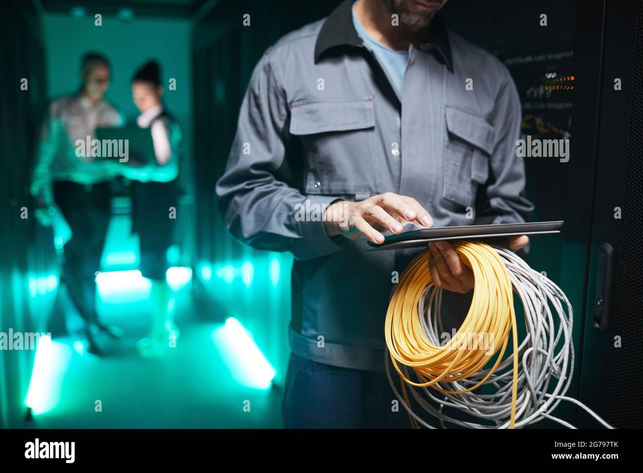 Ausgeschnittene Aufnahme eines Netzwerktechnikers mit digitalem Tablet im Serverraum während der Wartungsarbeiten im Rechenzentrum, Platz zum Kopieren Stockfoto