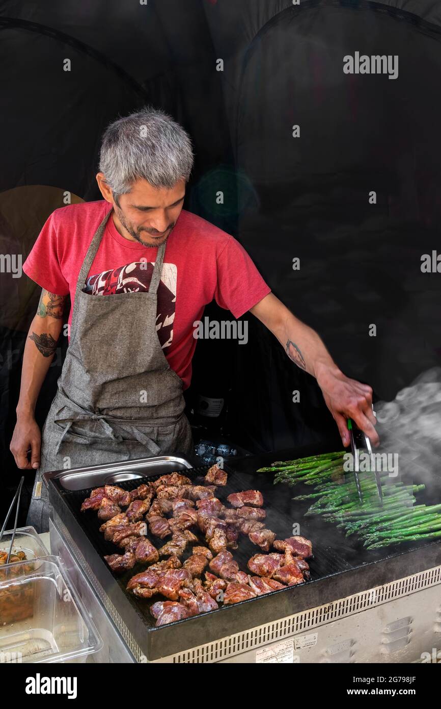 Ein Mann grillt Fleisch Stockfoto