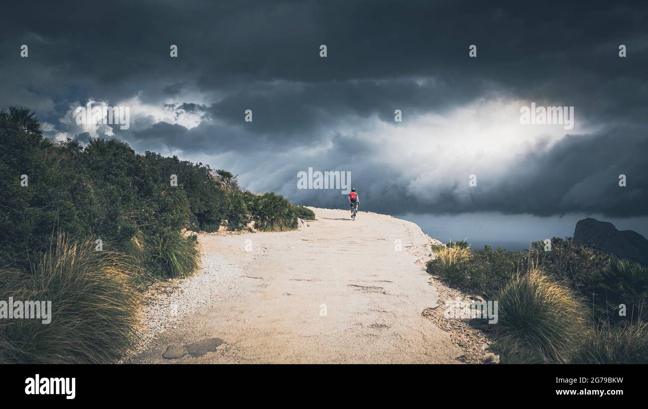 Dramatische Gewitteratmosphäre auf einem Berg mit Radfahrer Stockfoto