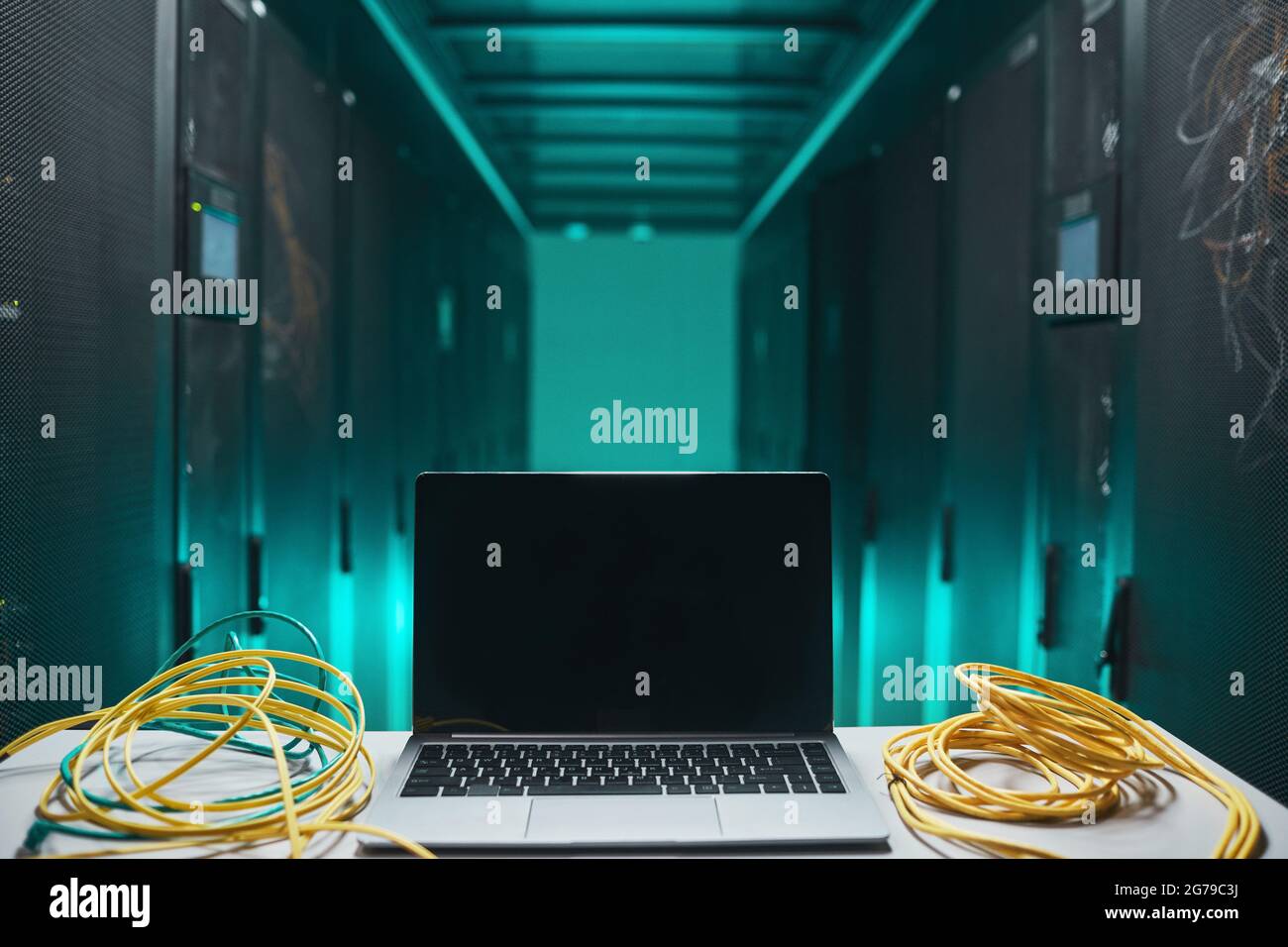 Hintergrundbild eines geöffneten Laptops mit Kabeln im Serverraum, Netzwerkwartungskonzept, Kopierplatz Stockfoto