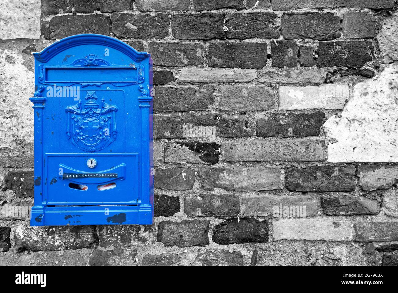 Blauer Briefkasten auf grauer Ziegelwand Stockfoto