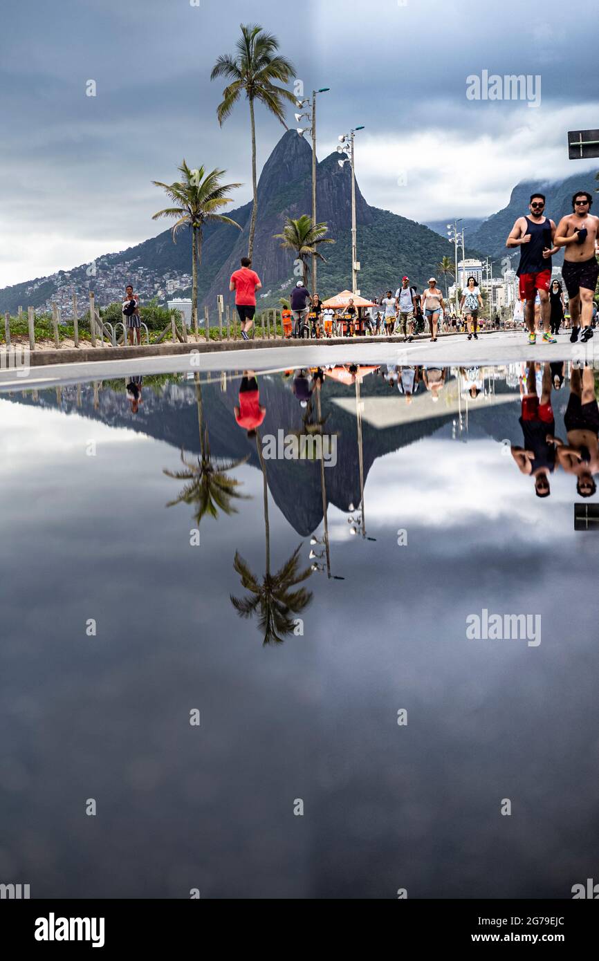 Großer Wasserpuddle nach Regen, der den Berg der zwei Brüder (Dois Irmaos) am Bürgersteig nahe dem Strand von Ipanema/Leblon in Rio de Janeiro, Brasilien, reflektiert. Leica M10 Stockfoto