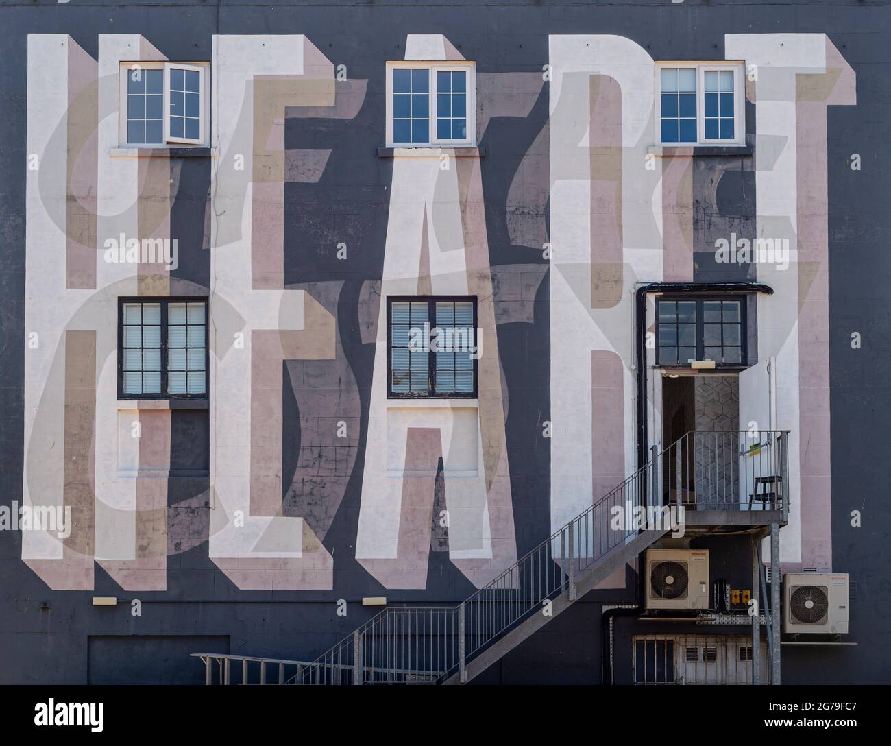 Stadtgebäude mit dem Wort „Herz“ an der Wand gestrichen. Stockfoto